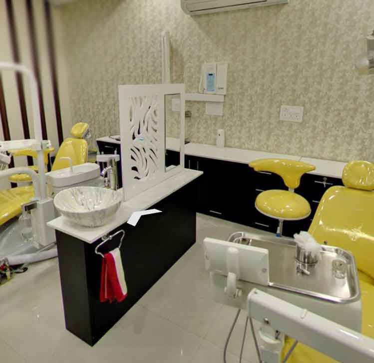 Interior of a dental office with yellow chairs and sinks.